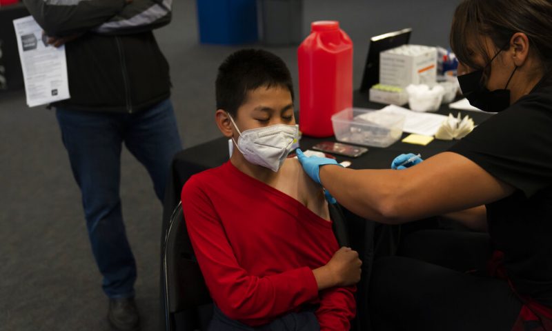 FILE - A youngster receives the Pfizer COVID-19 vaccine at a pediatric vaccine clinic for children ages 5 to 11 set up at Willard Intermediate School in Santa Ana, Calif., Tuesday, Nov. 9, 2021. State Sen. Richard Pan, D-Sacramento, announced, Thursday, April 14, 2022 that he is withdrawing his bill that would have stopped parents from getting exemptions for their child based on personal beliefs. (AP Photo/Jae C. Hong, File)