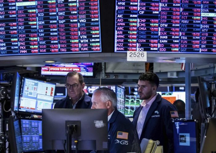In this photo provided by the New York Stock Exchange, a trio of specialists work at a post on the floor, Monday, June 13, 2022. (Courtney Crow/New York Stock Exchange via AP)