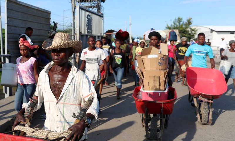 FILE PHOTO: Haitians cross the border between Haiti and the Dominican Republic to sell Haitian products at a market in Dajabon, Dominican Republic, September 23, 2019. REUTERS/Ricardo Rojas