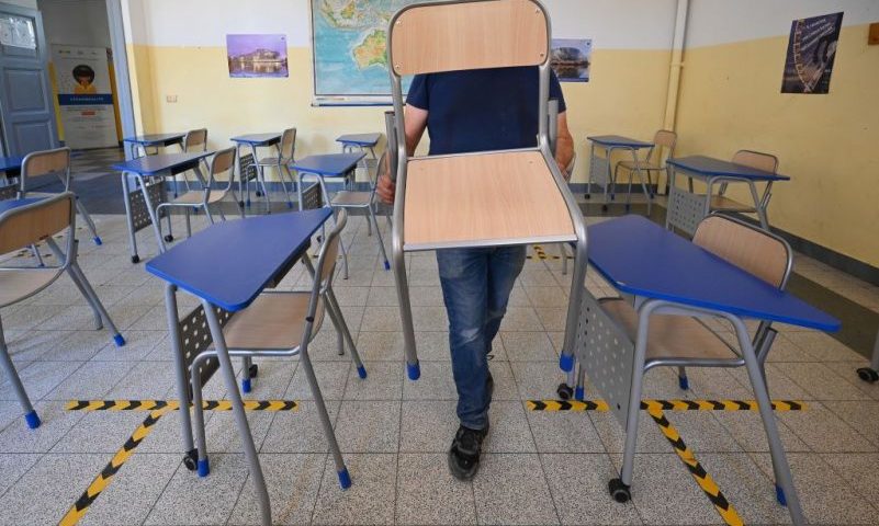 A worker sets up desks and chairs on September 4, 2020 in a classroom of the Luigi Einaudi technical high school in Rome prior to its reopening, during the the COVID-19 infection, caused by the novel coronavirus. - Millions of Italian pupils go back to the benches next week after six months at home, confronting a new reality of outdoor classes, coronavirus "isolation rooms" and even a possible ban on singing. (Photo by Vincenzo PINTO / AFP) (Photo by VINCENZO PINTO/AFP via Getty Images)