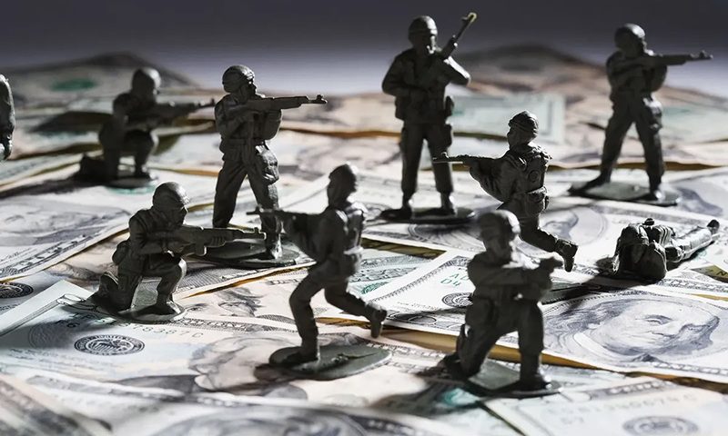 Toy soldier fighting on money (Getty Images)