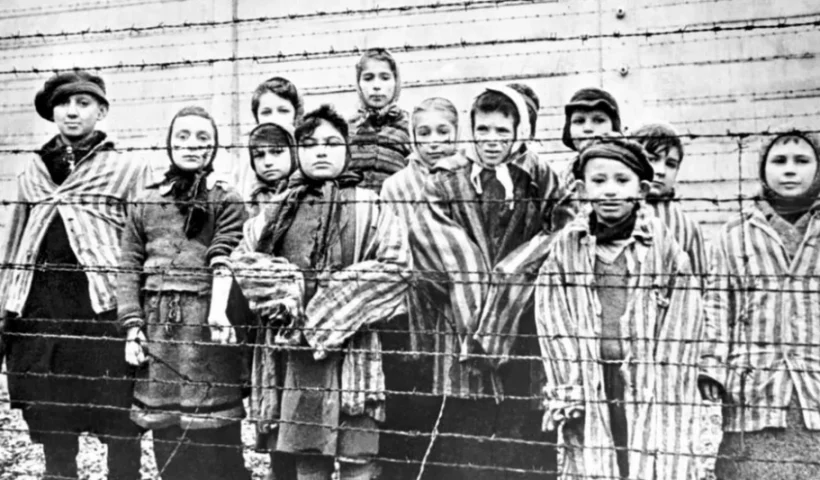 A group of child survivors behind a barbed wire fence at the Nazi concentration camp at Auschwitz (GETTY Images)