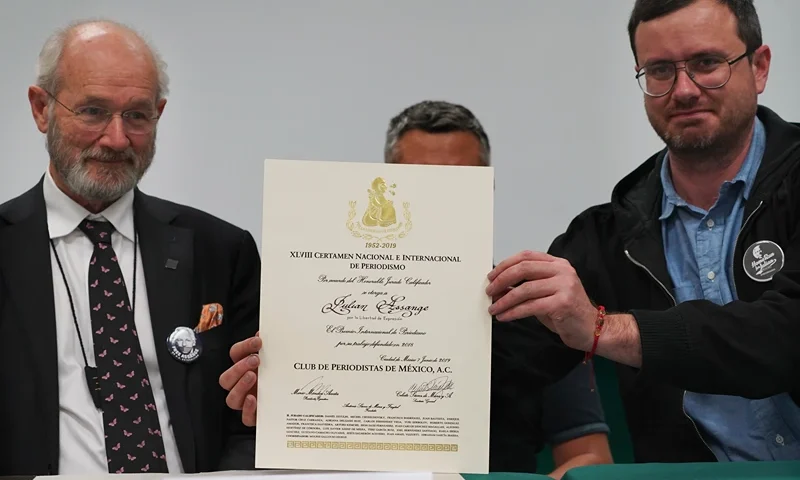 John Shipton and Gabriel Shipton, Julian Assange's father and brother respectively, display a diploma awarded by Mexico's Julian journalists' club during an event sponsored by the Mexican ruling party Morena, at the Telefónica Union headquarters, titled "Freedom for Julian Asange: A Global Struggle ," in Mexico City, on Wednesday, September 14, 2022 (AP Photo/Marco Ugarte)