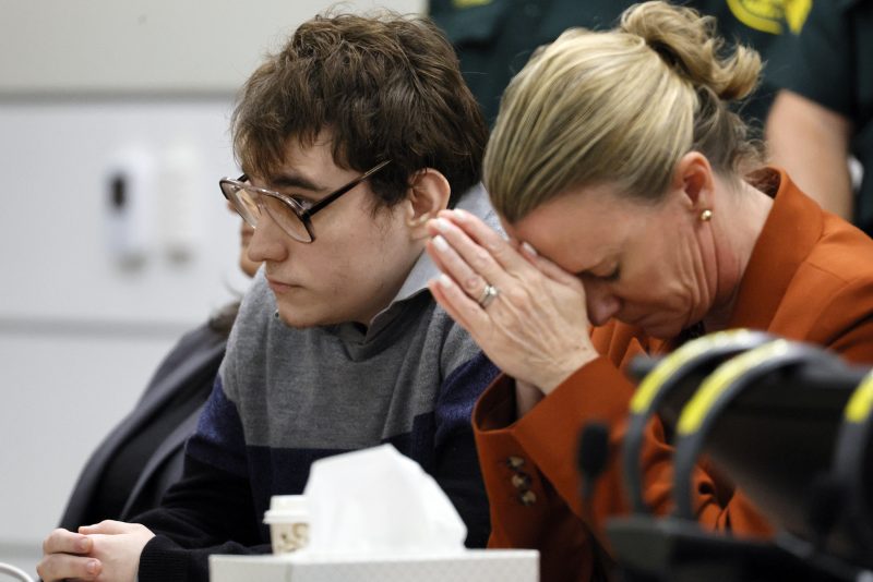 Assistant public defender Melisa McNeill, seated with Marjory Stoneman Douglas High School shooter Nikolas Cruz touches her hands to her head as the last of the 17 verdicts were read in the penalty phase of Cruz's trial at the Broward County Courthouse in Fort Lauderdale, Fla., on Thursday, Oct. 13, 2022. Cruz will be sentenced to life without parole for the 2018 massacre of 17 people at Parkland’s Marjory Stoneman Douglas High School. That sentence comes after the jury announced Thursday that it could not unanimously agree that Cruz should be executed. (Amy Beth Bennett/South Florida Sun-Sentinel via AP, Pool)