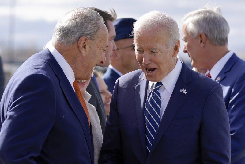 President Joe Biden reacts as he talks with Senate Majority Leader Chuck Schumer of N.Y., left, as he arrives Hancock Field Air National Guard Base in Mattydale, N.Y., Thursday, Oct. 27, 2022. (AP Photo/Manuel Balce Ceneta)