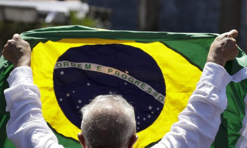 Former Brazilian President Luiz Inacio Lula da Silva, who is running for president again, holds a Brazilian flag after voting in a presidential run-off election in Sao Paulo, Brazil, Sunday, Oct. 30, 2022.(AP Photo/Marcelo Chello)