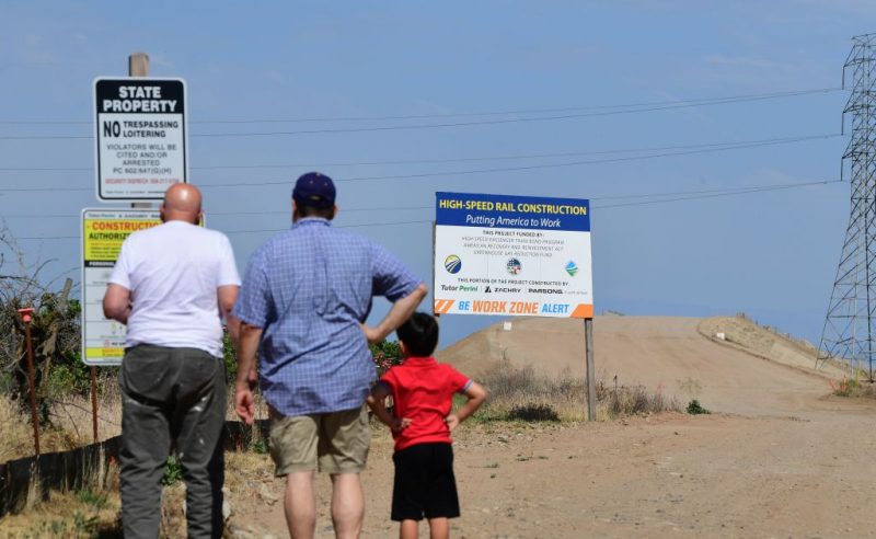 People read signs near a constuction site off Avenue 12 in Madera, California just north of Fresno on the California High Speed-Railway on May 5, 2019. - For more than five years residents and businesses have been disrupted and relocated up and down California's central San Joaquin Valley from the aquisition of property for the bullet-train's right of way. Now some of the former owners of property along the route are wondering if their sacrifices have been for nothing as changes in priorities for the project fuels uncertainty. (Photo by Frederic J. BROWN / AFP) (Photo credit should read FREDERIC J. BROWN/AFP via Getty Images)