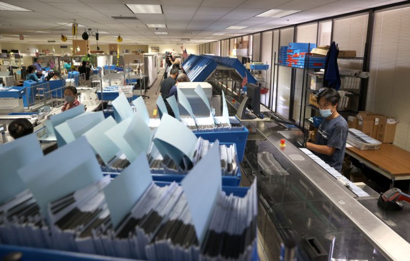 SAN JOSE, CALIFORNIA - AUGUST 25: A worker runs mail-in-ballots through a sorting machine at the Santa Clara County registrar of voters office on August 25, 2021 in San Jose, California. The Santa Clara County registrar of voters is preparing to take in and process thousands of ballots in the recall election of Gov. Gavin Newsom as early voting is underway in the state of California. (Photo by Justin Sullivan/Getty Images)