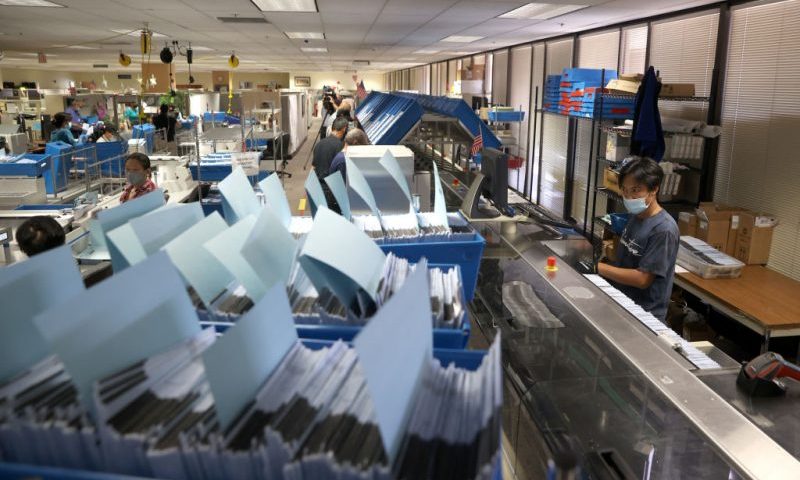 SAN JOSE, CALIFORNIA - AUGUST 25: A worker runs mail-in-ballots through a sorting machine at the Santa Clara County registrar of voters office on August 25, 2021 in San Jose, California. The Santa Clara County registrar of voters is preparing to take in and process thousands of ballots in the recall election of Gov. Gavin Newsom as early voting is underway in the state of California. (Photo by Justin Sullivan/Getty Images)