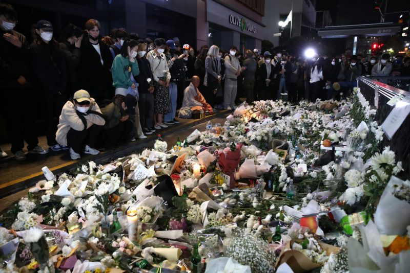 SEOUL, SOUTH KOREA - OCTOBER 31: People pay tribute for the victims of the Halloween celebration stampede, on the street near the scene on October 31, 2022 in Seoul, South Korea. One hundred and fifty-one people have been reported killed and at least 150 others were injured in a deadly stampede in Seoul's Itaewon district, after huge crowds of people gathered for Halloween parties, according to fire authorities. (Photo by Chung Sung-Jun/Getty Images)