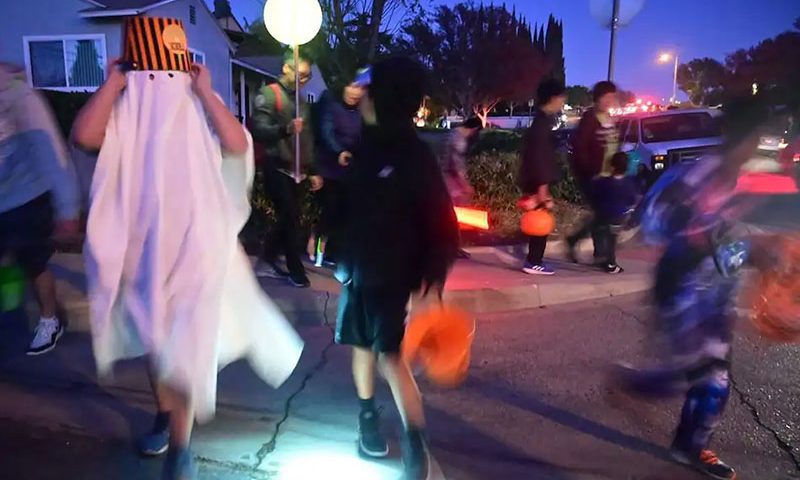 Children go trick or treating on Halloween night in Monterey Park, California on October 31, 2019. - Halloween is a major event for the American economy, from costumes and candy to lighting and decorations, with total spending forecast to reach 8.8 billion in 2019. (Photo by Frederic J. BROWN / AFP) (Photo by FREDERIC J. BROWN/AFP via Getty Images)