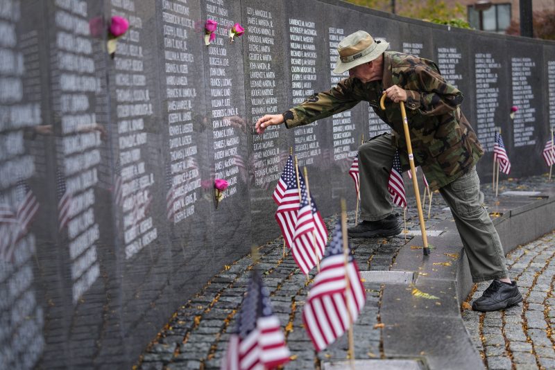 Army veteran Henry Ruszkowski touches the name of one of eight friends names etched on the wall at the Vietnam War Memorial in Philadelphia on Veterans Day, Friday, Nov. 11, 2022. (AP Photo/Matt Rourke)