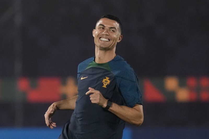 Portugal's Cristiano Ronaldo smiles as he warms up during the Portugal's official training on the eve of the group H World Cup soccer match between Portugal and Ghana at the Al Shahaniya SC training site in Al Shahaniya, Qatar, Wednesday, Nov. 23, 2022. (AP Photo/Lee Jin-man)