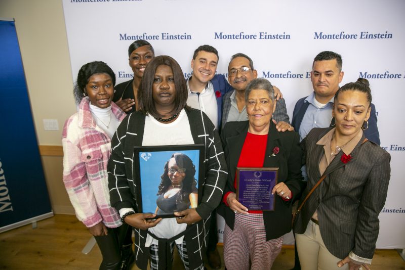 Bridgette Newton holds a picture of her late daughter Brittany Newton next to Miriam Nieves, holding a plaque, who received Brittany Newton's heart in a transplant at Montefiore Moses Hospital in the Bronx borough of New York, on Tuesday, Nov. 22, 2022. Their families stand with them. Doctors at the hospital say the transplant, performed in April, is the first time a heart from an HIV-positive donor was successfully transplanted into an HIV-positive recipient. (AP Photo/Ted Shaffrey)