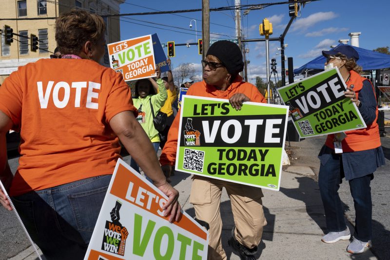 People gather during a get out the vote rally Sunday, Nov. 27, 2022, in Atlanta, during early voting for the Senate runoff election. (AP Photo/Ben Gray)