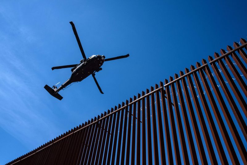 A US border patrol helicopter overflies the US-Mexico border fence as US President Donald Trump visits Calexico, California, as seen from Mexicali, Baja California state, Mexico, on April 5, 2019. - President Donald Trump flew Friday to visit newly built fencing on the Mexican border, even as he retreated from a threat to shut the frontier over what he says is an out-of-control influx of migrants and drugs. (Photo by Guillermo Arias / AFP) (Photo credit should read GUILLERMO ARIAS/AFP via Getty Images)