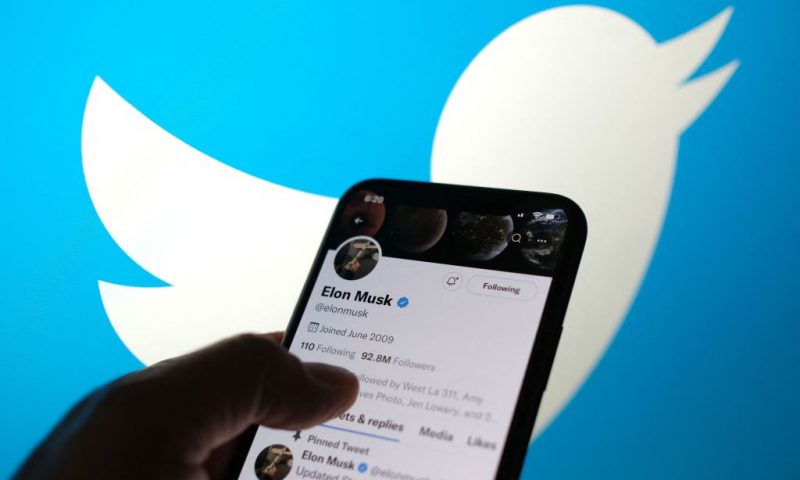This illustration photo taken May 13, 2022, displays Elon Musks Twitter account with a Twitter logo in the background in Los Angeles. - Elon Musk sent mixed messages Friday about his proposed Twitter acquisition, pressuring shares of the microblogging platform amid skepticism on whether the deal will close. In an early morning tweet, Musk said the $44 billion takeover was "temporarily on hold," pending questions over the social media company's estimates of the number of fake accounts or "bots." That sent Twitter's stock plunging 25 percent. (Photo by Chris DELMAS / AFP) (Photo by CHRIS DELMAS/AFP via Getty Images)