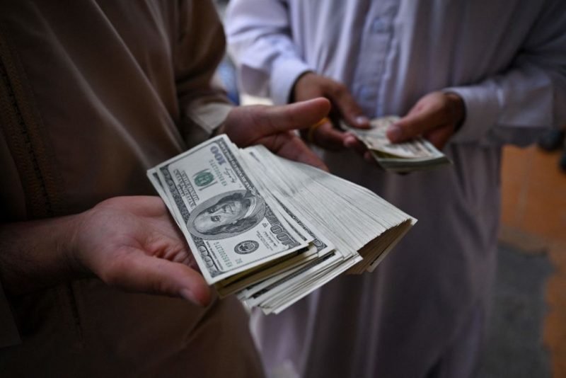 Currency traders show stacks of US dollars at the currency exchange centre in Herat city on August 4, 2022. (Photo by Lillian SUWANRUMPHA / AFP) (Photo by LILLIAN SUWANRUMPHA/AFP via Getty Images)