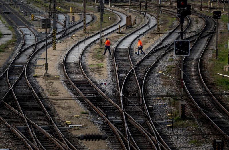 Workers walk over empty tracks of the Austrian railway operator OeBB at the Westbahnhof railway station in Vienna on November 28, 2022, during a warning strike of the railway workers over a wage dispute. - The Austrian trade union 