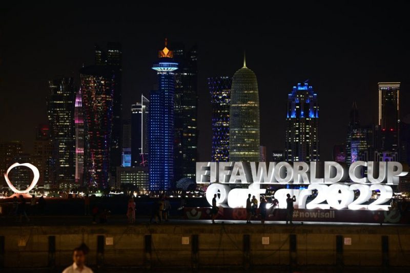 A photo shows a tournament sign on the Corniche promenade as skyscrapers of the West Bay are seen in the background in Doha, on November 28, 2022, during Qatar 2022 World Cup football tournament. (Photo by JUAN MABROMATA / AFP) (Photo by JUAN MABROMATA/AFP via Getty Images)