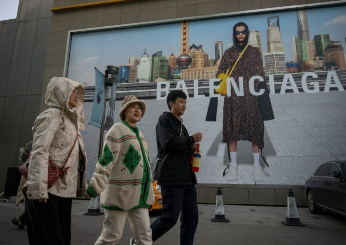 BEIJING, CHINA - OCTOBER 16: People walk in front of a Balenciaga ad on October 16, 2021 in Beijing, China. According to an action plan released on October 14, Beijing has unveiled a series of measures aimed at building the city into an international consumption center over the next five years. (Photo by Andrea Verdelli/Getty Images)