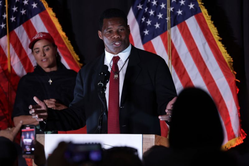 ATLANTA, GEORGIA - NOVEMBER 08: Republican U.S. Senate candidate Herschel Walker speaks to supporters as his wife Julie Blanchard looks on during an election night event on November 8, 2022 in Atlanta, Georgia. Herschel Walker, the University of Georgia Heisman Trophy winner and former NFL running back, faces incumbent Sen. Raphael Warnock (D-GA) in today’s general election. (Photo by Alex Wong/Getty Images)