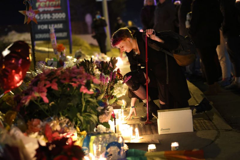 People hold a vigil at a makeshift memorial near the Club Q nightclub on November 20, 2022 in Colorado Springs, Colorado. Yesterday, a 22-year-old gunman entered the LGBTQ nightclub and opened fire, killing at least five people and injuring 25 others before being stopped by club patrons. (Photo by Scott Olson/Getty Images)