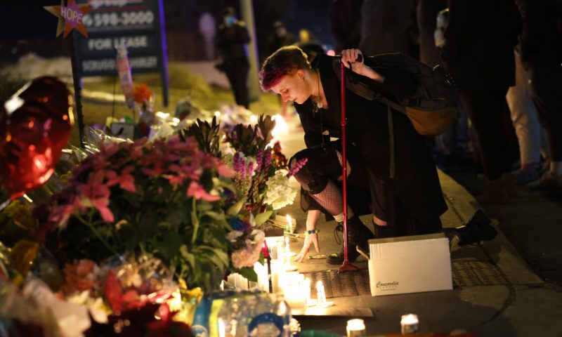 People hold a vigil at a makeshift memorial near the Club Q nightclub on November 20, 2022 in Colorado Springs, Colorado. Yesterday, a 22-year-old gunman entered the LGBTQ nightclub and opened fire, killing at least five people and injuring 25 others before being stopped by club patrons. (Photo by Scott Olson/Getty Images)