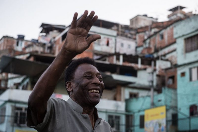 Legendary Brazilian former football player Pele waves during the inauguration ceremony of the new technology football pitch installed at Mineira favela in Rio de Janeiro, Brazil, on September 10, 2014. 200 self energy supplied  Pavegen panels, invented by British Laurence Kemball-Cook, were installed underground to capture kinetic energy created by the movement of the football players. The energy is stored and combined with solar panels' energy to illuminate the pitch during the night. The new technology pitch was created by oil giant Royal Dutch Shell.  AFP PHOTO / YASUYOSHI CHIBA (Photo by Yasuyoshi CHIBA / AFP) (Photo by YASUYOSHI CHIBA/AFP via Getty Images)