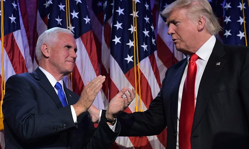 Republican presidential elect Donald Trump (R) reaches to his Vice President elect Mike Pence during election night at the New York Hilton Midtown in New York on November 9, 2016. Trump stunned America and the world Wednesday, riding a wave of populist resentment to defeat Hillary Clinton in the race to become the 45th president of the United States. / AFP / MANDEL NGAN (Photo credit should read MANDEL NGAN/AFP via Getty Images)