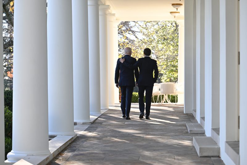 President Joe Biden and French President Emmanuel Macron walk down the Colonnade of the White House in Washington, Thursday, Dec. 1, 2022. (Jim Watson/Pool Photo via AP)