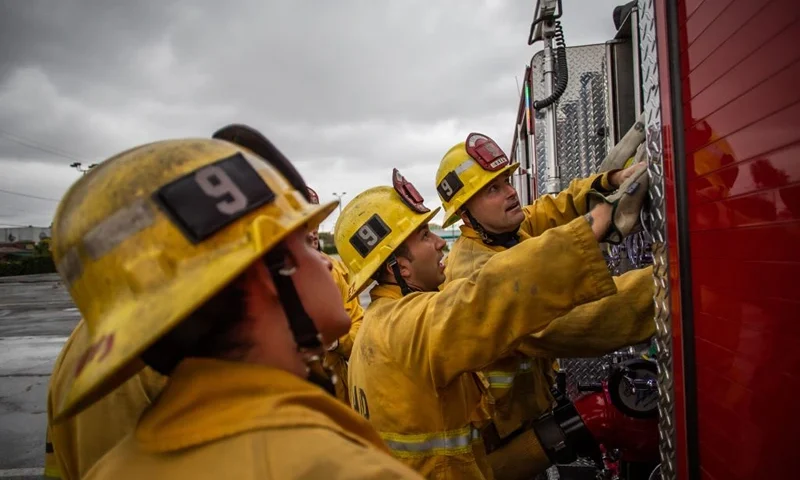 Firefighters look up to fire truck instruments in a morning training session of the LAFD Station No9 team at Skid Row on April 12, 2020 in downtown Los Angeles, California. (Photo by Apu GOMES / AFP) (Photo by APU GOMES/AFP via Getty Images)