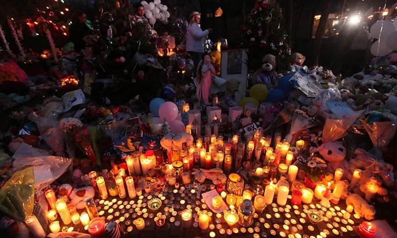 Candles are lit among mementos at a memorial for victims of the mass shooting at Sandy Hook Elementary School, on December 17, 2012 in Newtown, Connecticut. The first two funerals for victims of the shooting were held today. (Photo by Mario Tama/Getty Images)