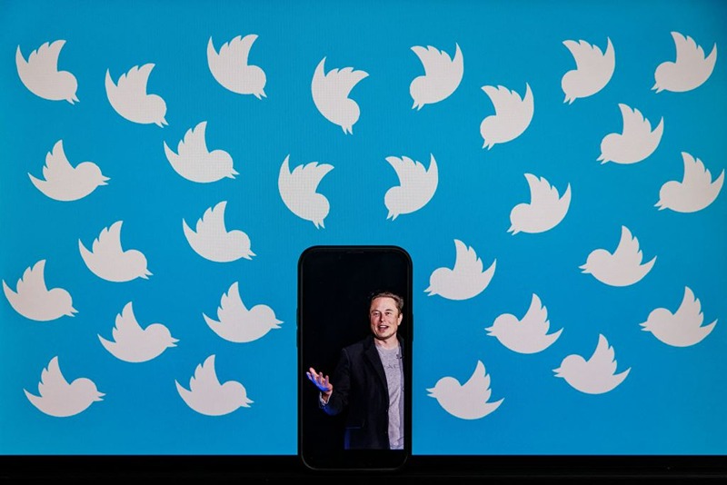 This illustration photo taken on August 5, 2022 shows a cellphone displaying a photo of Elon Musk placed on a computer monitor filled with Twitter logos in Washington, DC. - Elon Musk has accused Twitter of fraud, alleging the social media platform misled him about key aspects of its business before he agreed to a $44 billion buyout, as their court battle heats up. (Photo by SAMUEL CORUM / AFP) (Photo by SAMUEL CORUM/AFP via Getty Images)