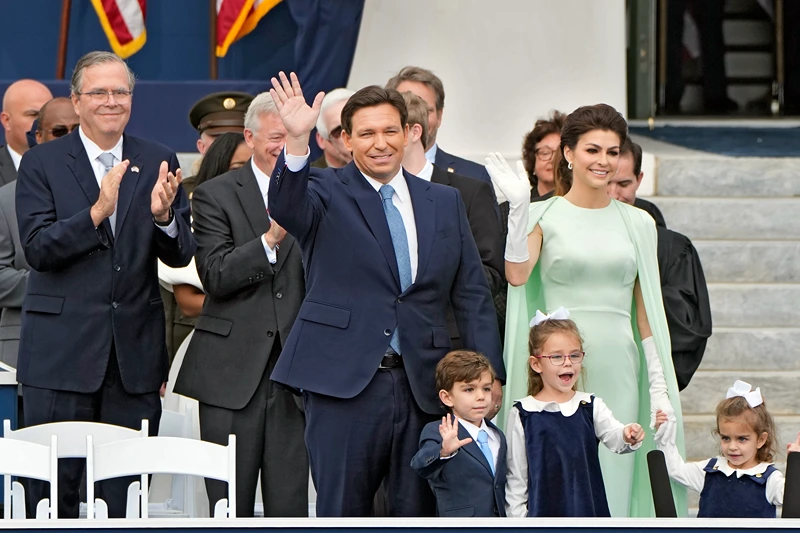 Florida Gov. Ron DeSantis, center, waves as he arrives with his wife Casey, right, and their children Mason, Madison, and Mamie before his inauguration ceremony outside the Old Capitol Tuesday, Jan. 3, 2023, in Tallahassee, Fla. Applauding at a left is former governor Jeb Bush. (AP Photo/Lynne Sladky).