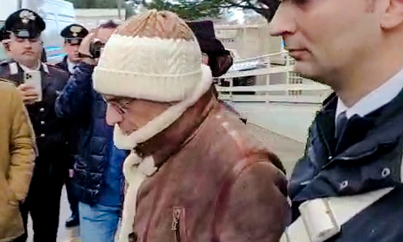 This was picture taken from a video released by Italian Carabinieri on Monday, January 16, 2023, top Mafia boss Matteo Messina Denaro, center, leaves an Italian Carabinieri barrack soon after his arrest at a private clinic in Palermo, Sicily, after 30 years on the run, Monday, Jan. 16, 2023. (Carabinieri via AP)