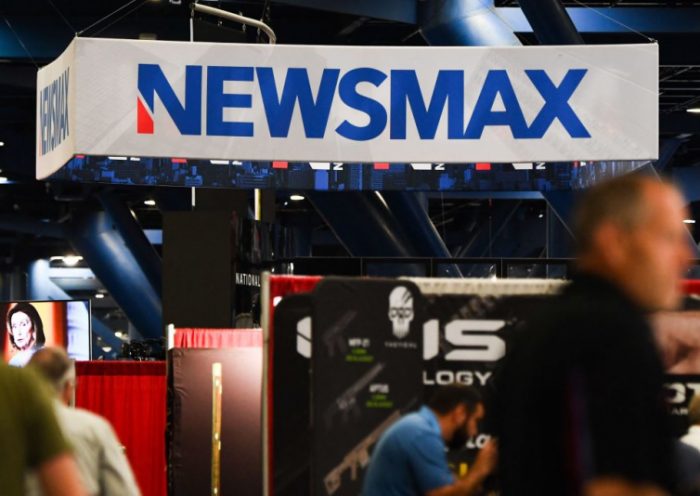 Signage for the Newsmax conservative television broadcasting network is displayed at a broadcast TV booth at the National Rifle Association (NRA) annual meeting at the George R. Brown Convention Center, in Houston, Texas on May 28, 2022. - America's powerful National Rifle Association kicked off a major convention in Houston Friday, days after the horrific massacre of children at a Texas elementary school, but a string of high-profile no-shows underscored deep unease at the timing of the gun lobby event. (Photo by Patrick T. FALLON / AFP) (Photo by PATRICK T. FALLON/AFP via Getty Images)