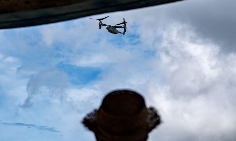 This picture taken on August 23, 2022 shows an MV-22 Osprey tilt-rotor aircraft in flight after taking off from US Marine Corps Air Station Futenma, as a person looks on towards the military base from Kakazutakadai Park in the city of Ginowan, Okinawa prefecture. - For decades, residents of Japan's Okinawa have strongly opposed the US military bases that dot the region, but a subtle shift is underway, driven by Chinese sabre-rattling and economic challenges. - TO GO WITH Japan-Okinawa-defence-US-China,FOCUS by Mathias CENA (Photo by PHILIP FONG / AFP) / TO GO WITH Japan-Okinawa-defence-US-China,FOCUS by Mathias CENA (Photo by PHILIP FONG/AFP via Getty Images)
