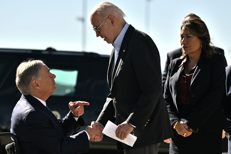 US President Joe Biden shakes hands with Texas Governor Greg Abbott after Abbott handed him a letter outlining the problems on the southern border upon arrival at El Paso International Airport in El Paso, Texas, on January 8, 2023. (Photo by Jim WATSON / AFP) (Photo by JIM WATSON/AFP via Getty Images) 

