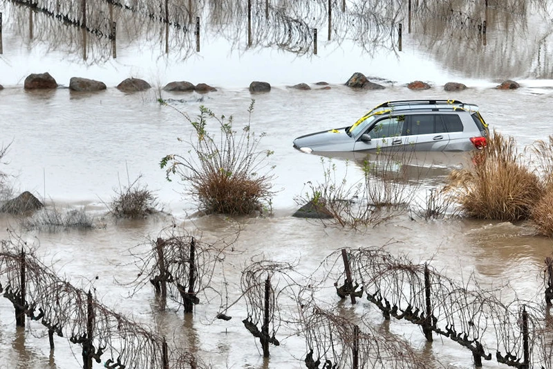 WINDSOR, CALIFORNIA - JANUARY 09: In an aerial view, a car is submerged in floodwater after heavy rain moved through the area on January 09, 2023 in Windsor, California. The San Francisco Bay Area continues to get drenched by powerful atmospheric river events that have brought high winds and flooding rains. The storms have toppled trees, flooded roads and cut power to tens of thousands of residents. Storms are lined up over the Pacific Ocean and are expected to bring more rain and wind through the end of the week. (Photo by Justin Sullivan/Getty Images)