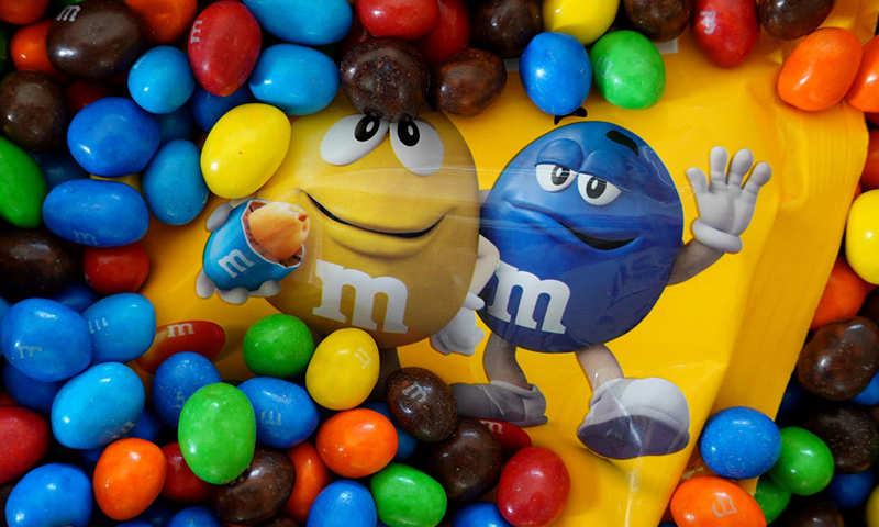 In this photo illustration, M&M's are piled in a container on January 24, 2023 in Miami, Florida. M&M's announced that its multi-colored cast of candy cartoon spokespeople will be retiring effective immediately, and will be replaced by comedian and Saturday Night Live alum Maya Rudolph. (Photo Illustration by Joe Raedle/Getty Images)
