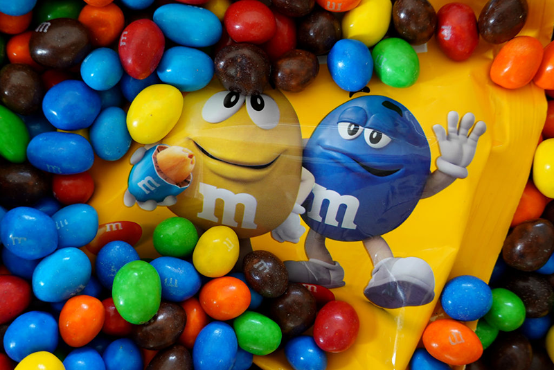 In this photo illustration, M&M's are piled in a container on January 24, 2023 in Miami, Florida. M&M's announced that its multi-colored cast of candy cartoon spokespeople will be retiring effective immediately, and will be replaced by comedian and Saturday Night Live alum Maya Rudolph. (Photo Illustration by Joe Raedle/Getty Images)