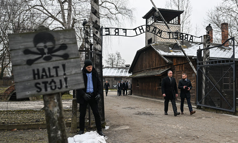 U.S. Second Gentleman, Douglas Emhoff (2R), walks past the main gate of the former Auschwitz Concentration Camp during the Holocaust Remembrance Day at the former Auschwitz I site on January 27, 2023 in Oswiecim, Poland. International Holocaust Remembrance Day, 27 January, is observed on the anniversary of the liberation of Auschwitz-Birkenau, the largest Nazi death camp. (Photo by Omar Marques/Getty Images)