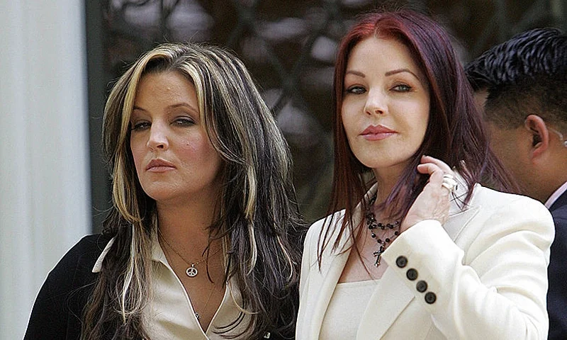 Priscilla Presley (R) and her daughter Lisa Marie Presley (L) wait at the front portico entrance to greet US President George W. Bush and Prime Minister Junichiro Koizumi of Japan for a private tour of Elvis Presley's Graceland Mansion 30 June, 2006 in Memphis, Tennessee. AFP PHOTO / TIM SLOAN (Photo credit should read TIM SLOAN/AFP via Getty Images)