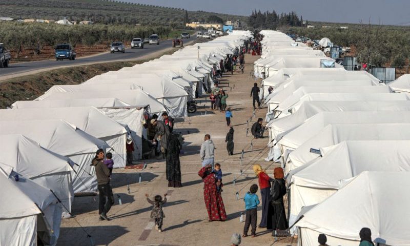 People walk along an alley between tents at a camp for the displaced erected in the aftermath of the February 6 deadly earthquake that hit Syria and Turkey, in Jindayris in northwestern Syria on February 19, 2023. (Photo by Bakr ALKASEM / AFP) (Photo by BAKR ALKASEM/AFP via Getty Images)