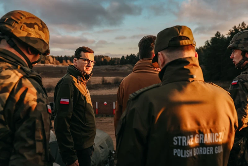  In this handout image provided by the Polish Ministry Of Defence, Polish Prime Minister Mateusz Morawiecki speaks with border army units at the Belarusian-Polish border as migrants gather on the border on November 09, 2021 in Kuznica, Poland. The situation on the border between Poland and Belarus continues to intensify, as hundreds of migrants arrive at the Polish border to join the EU. (Photo by Polish Ministry Of Defence via Getty Images)