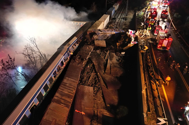 Smoke rises from trains as firefighters and rescuers operate after a collision near Larissa city, Greece, early Wednesday, March 1, 2023. The collision between a freight and passenger train occurred near Tempe, some 380 kilometers (235 miles) north of Athens, and resulted in the derailment of several train cars. (AP Photo/Vaggelis Kousioras)