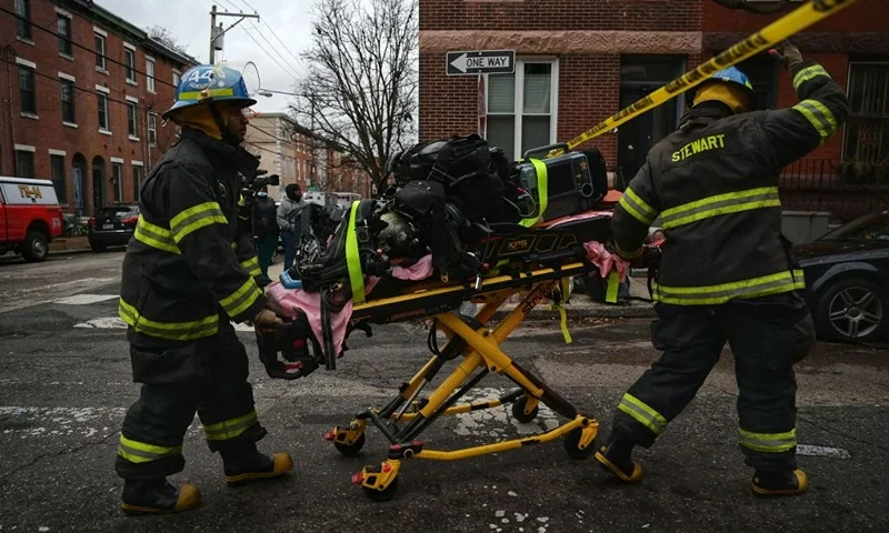 Firefighter paramedics work at the scene of a deadly fire on January 5, 2022, in Philadelphia's popular museum district of Fairmount. - Thirteen people, including seven children, died when a fire tore through a converted three-story house in the eastern US city of Philadelphia on January 5, officials said. The blaze was one of the deadliest in recent memory in America's sixth-most populous metropolis. (Photo by Ed JONES / AFP) (Photo by ED JONES/AFP via Getty Images)