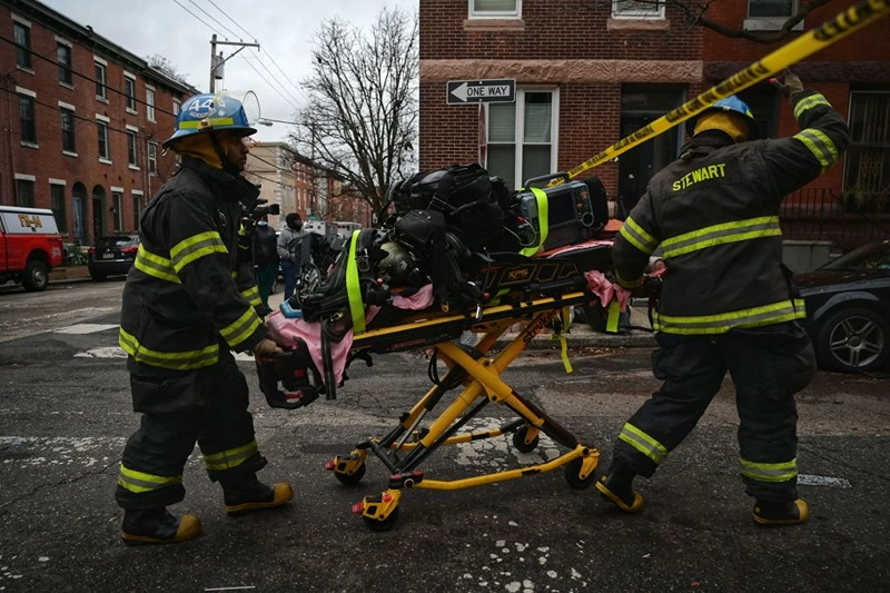  Firefighter paramedics work at the scene of a deadly fire on January 5, 2022, in Philadelphia's popular museum district of Fairmount. - Thirteen people, including seven children, died when a fire tore through a converted three-story house in the eastern US city of Philadelphia on January 5, officials said. The blaze was one of the deadliest in recent memory in America's sixth-most populous metropolis. (Photo by Ed JONES / AFP) (Photo by ED JONES/AFP via Getty Images)