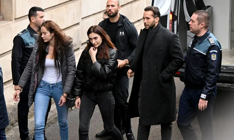 British-US former professional kickboxer and controversial influencer Andrew Tate (3rd R), his brother Tristan Tate (2nd R), and two unidentified Romanian women, arrive handcuffed and escorted by police at a courthouse in Bucharest on January 10, 2023 for a court hearing on their appeal against pre-trial detention for alleged human trafficking, rape and forming a criminal group. (Photo by Daniel MIHAILESCU / AFP) (Photo by DANIEL MIHAILESCU/AFP via Getty Images)
